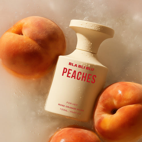 Bottle of BLA BLU Peaches men perfume surrounded by peaches on a textured background