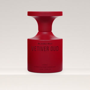 Red vetiver  perfume bottle labeled 'Vetiver Oud' on a light gray background