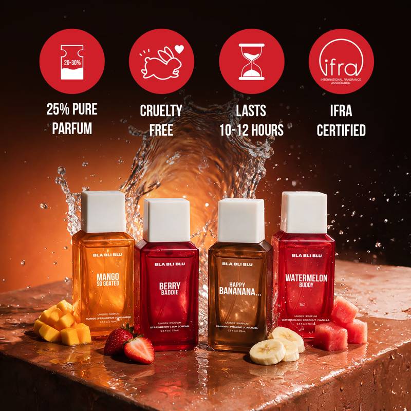 Four small fragrance bottles labeled Bla bli blu with white caps are arranged on a wet surface with fruit pieces.