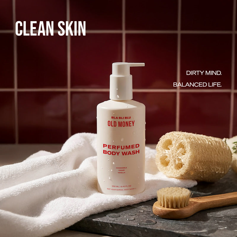 Body wash bottle with a towel, sponge, and brush on a bathroom counter.