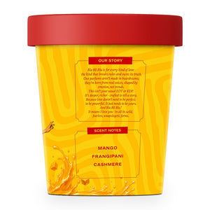 A yellow scented candle container with a red lid, featuring printed text sections for 'Our Story' and 'Scent Notes'