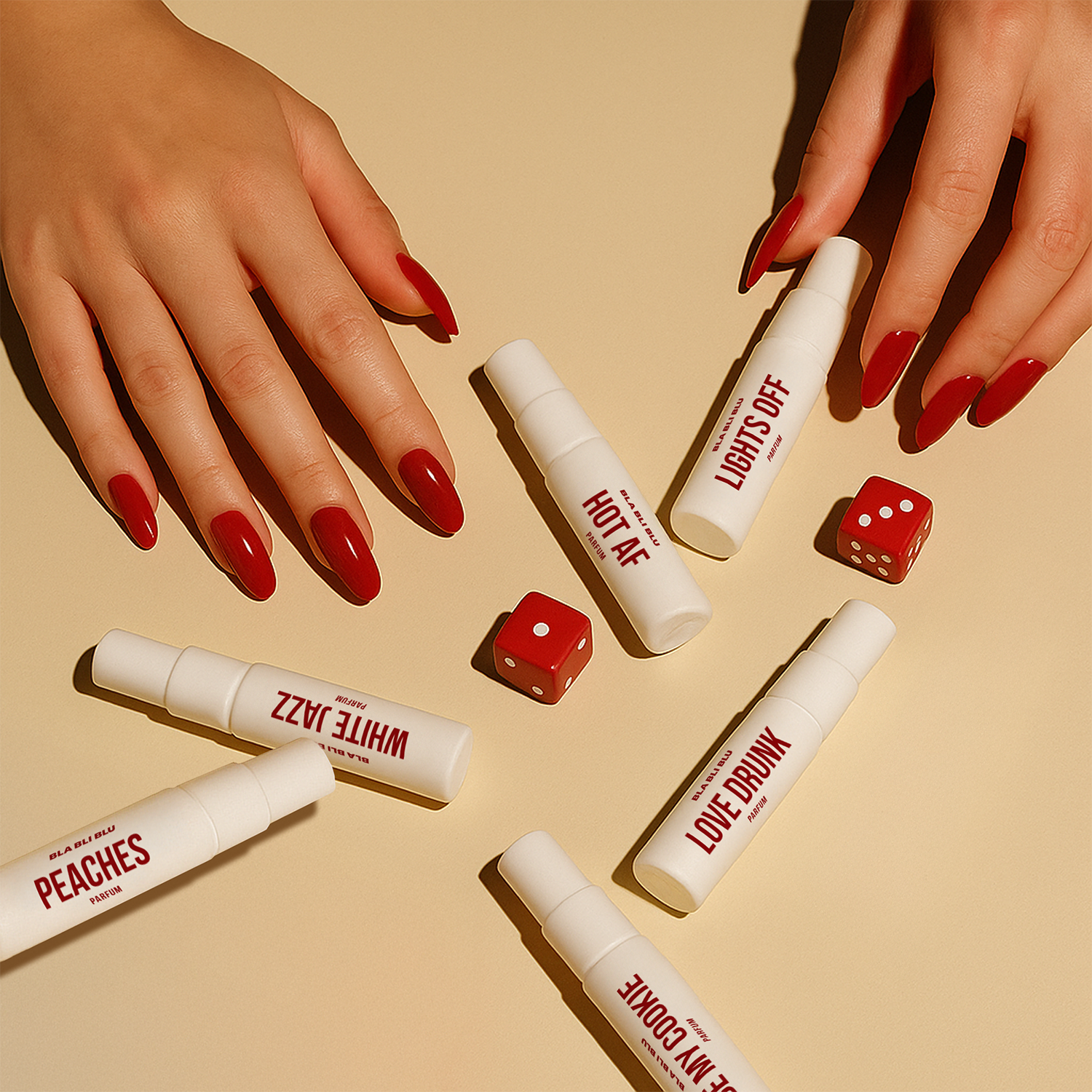 White lip gloss tubes with red text on a beige background, accompanied by red dice.