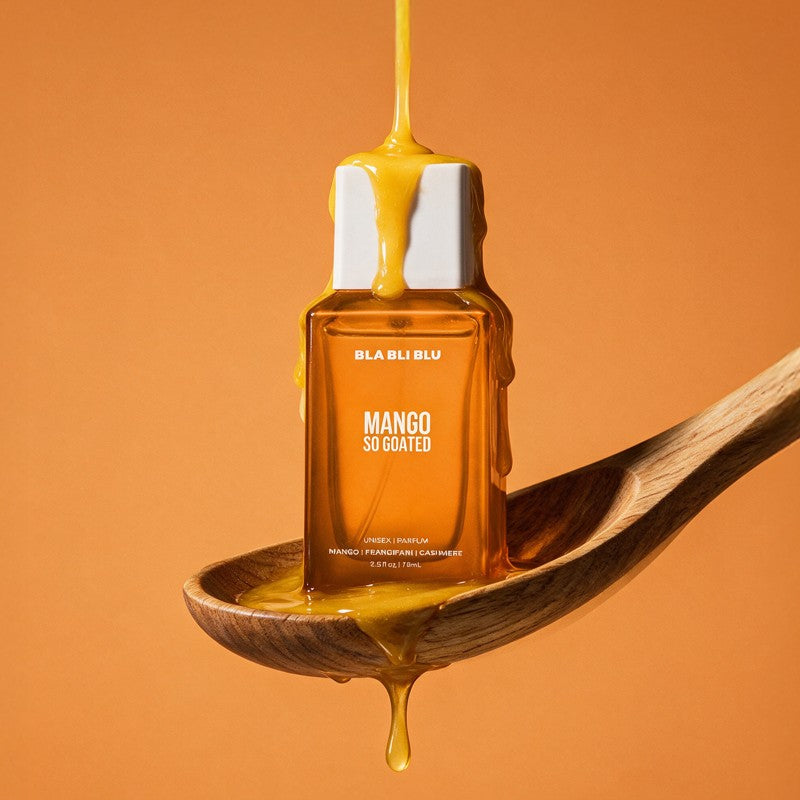 A rectangular amber bottle labeled BLA BLA BLU Mango So Gated, filled with golden honey and dripping over a white cap