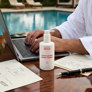 Bottle of Hustler Perfumed Body Wash on a desk by a pool.